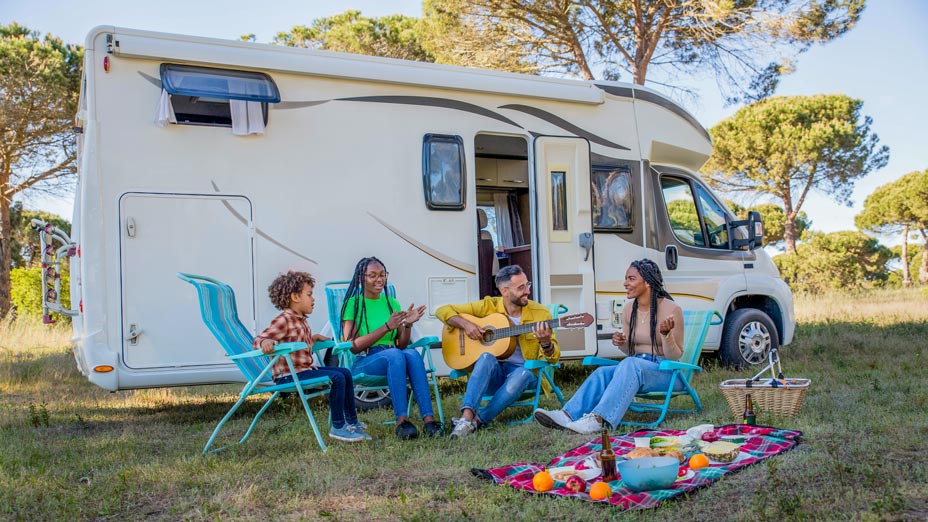 Moments conviviaux en famille avec guitare devant un camping-car