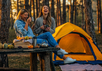 Vacancières heureuses posant devant une tente en pleine nature